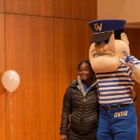 Image of female student taking a picture with Louis the Laker, GVSU Mascot